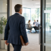 An experienced professional walking through a doorway toward a business meeting/interview